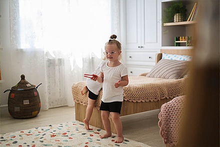 Gemeinsamen Aktivitäten stärken den Familien-Zusammenhalt Ein Mädchen tanzt im Kinderzimmer