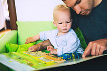 Vater und Kind betrachten ein Bilderbuch 