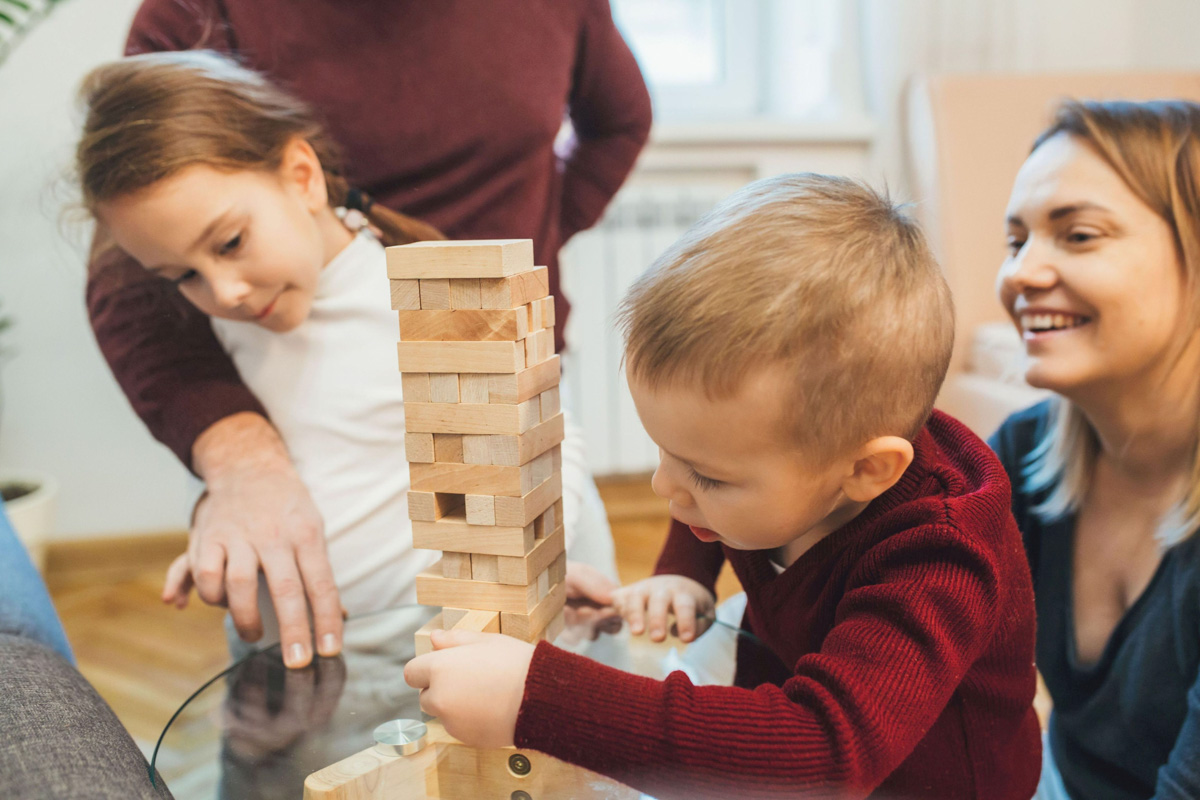 Famillie Jenga Familie spielt Bauklötze mit ihren Kinder